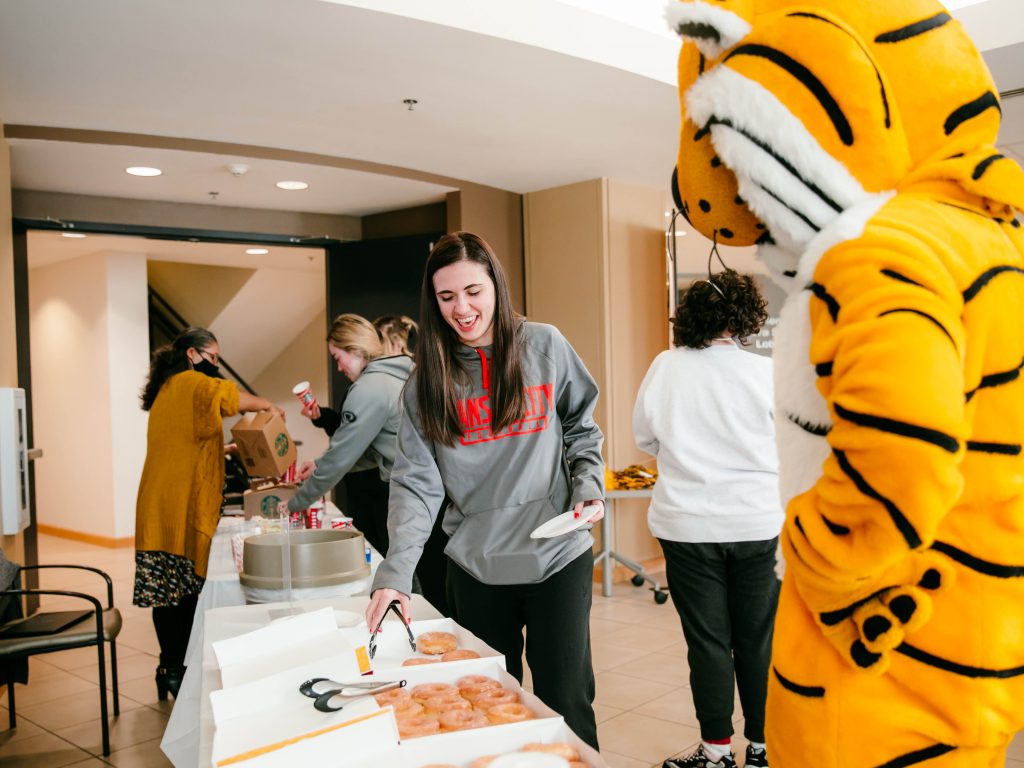 first-generation student celebration in Townsend Lobby, student getting a donut with Truman nearby