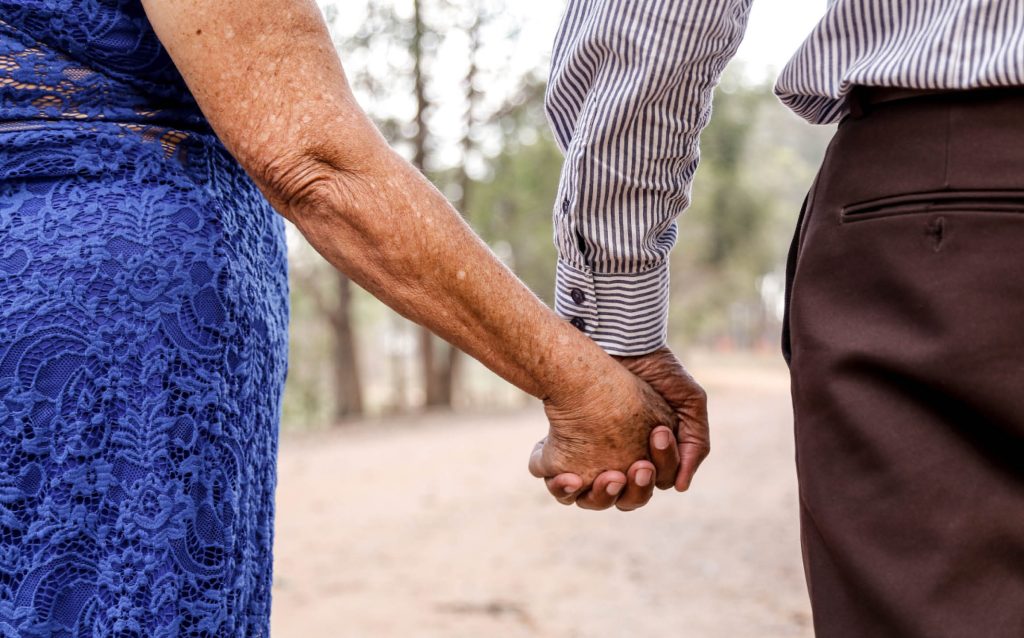 Photo of elderly couple holding hands