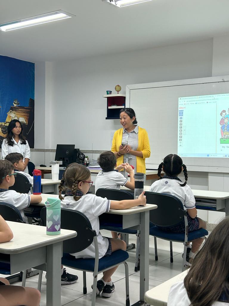 A teacher speaking to a class of young students.